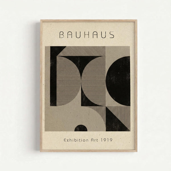 Framed vintage-style art print with cream background featuring geometric black and gray shapes including circles, lines, and angular forms in Bauhaus modernist style. The composition shows intersecting curved and straight elements with fine linear texturing. Text reads "BAUHAUS" at top and "Exhibition Art 1919" at bottom. Displayed in light wood frame against white wall.