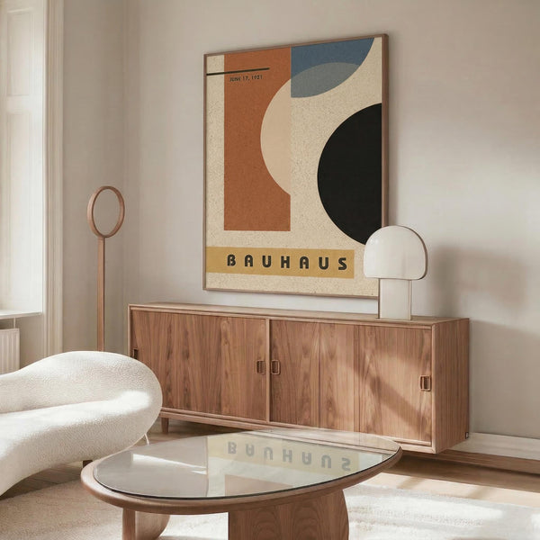 May include: Vintage-style Bauhaus poster with abstract geometric shapes in orange, blue, cream and dark green colors, dated June 17, 1921, displayed above mid-century modern walnut credenza in minimalist living room with white curved chair, glass coffee table, and brass floor lamp