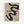 A minimalist poster with flowing black abstract shapes on beige textured paper, featuring bold "BAUHAUS" text and the phrase "FORM FOLLOWS FUNCTION". The design includes curved, serpentine forms that create negative space throughout the composition. Text at the bottom references "Weimar Juni - September 1919 Stuttgart Kunstgeboude am Schlossplatz". The poster is displayed in a thin light wood frame against a white wall.