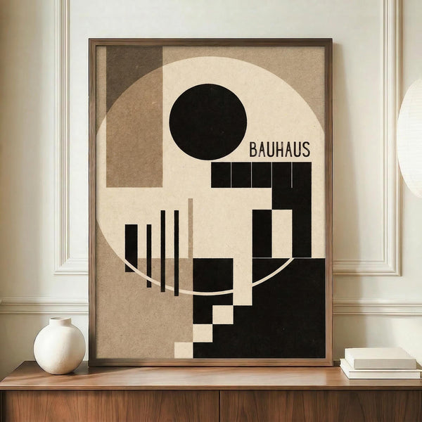 May include: Framed Bauhaus-style geometric poster with black circle, beige and brown rectangles, and vertical lines on neutral background, displayed on wooden credenza beside white ceramic vase and stacked books in elegant room with white paneled walls