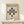 May include: Framed Bauhaus poster with beige textured background displaying black geometric shapes - circles and elongated forms arranged symmetrically. Bold black text reads "BAUHAUS" and "GEOMETRY AND SIMPLICITY" at top, with German exhibition details at bottom. Natural wood frame sits on light wooden shelf against white wall, with small white wrapped gift beside it.
