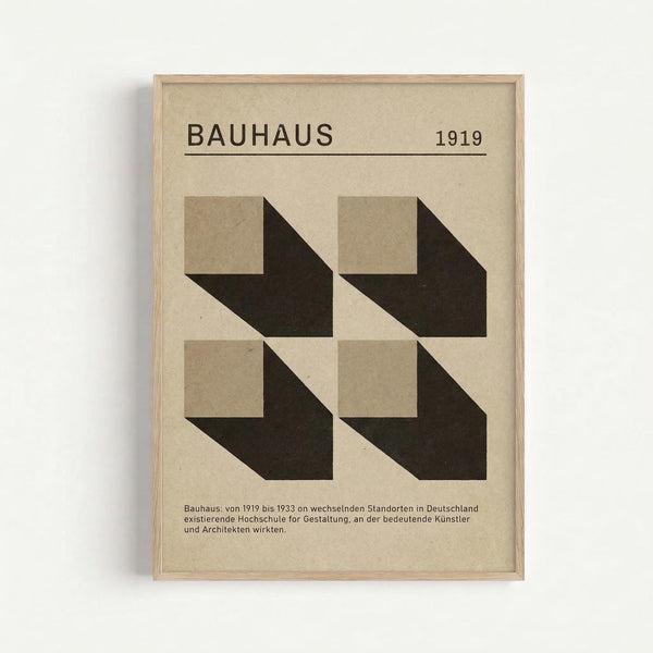 Minimalist framed poster with beige background featuring "BAUHAUS 1919" text at top and four geometric cube shapes arranged in a 2x2 grid below. Each cube shows dimensional perspective with light beige faces and dark brown/black sides creating shadow effects. German text appears at bottom. Natural wood frame against white wall.