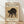 May include: Framed vintage-style poster leaning against white wall on light wood floor. Shows black cat in defensive arched pose with yellow eyes on aged beige background. Includes museum attribution text and Japanese characters. Natural wood frame with warm lighting creating soft shadows.