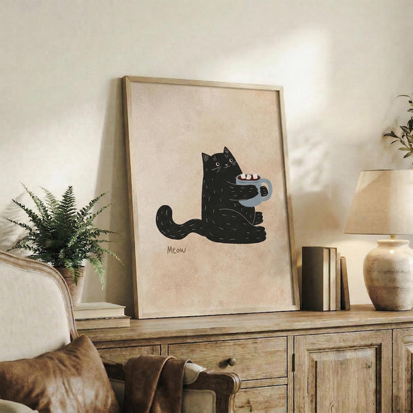 May include: Framed poster print featuring a black cat holding a mug with marshmallows and the word "Meow" below, displayed on a rustic wooden sideboard alongside books, a ceramic vase, and a fern plant in a cozy living room with neutral walls and brown leather furniture.