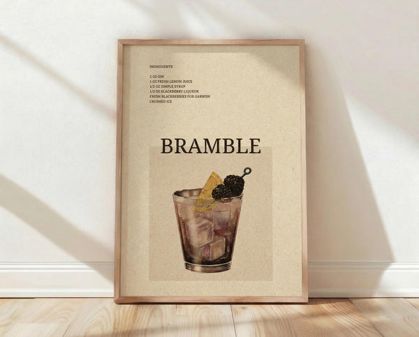 May include: Framed vintage-style cocktail recipe poster with cream background showing bramble drink illustration. Glass filled with ice, blackberry garnish, and lemon slice. Dark text lists gin, lemon juice, simple syrup, and blackberry liqueur ingredients. Natural wood frame leans against white wall on light wooden floor with soft shadows.