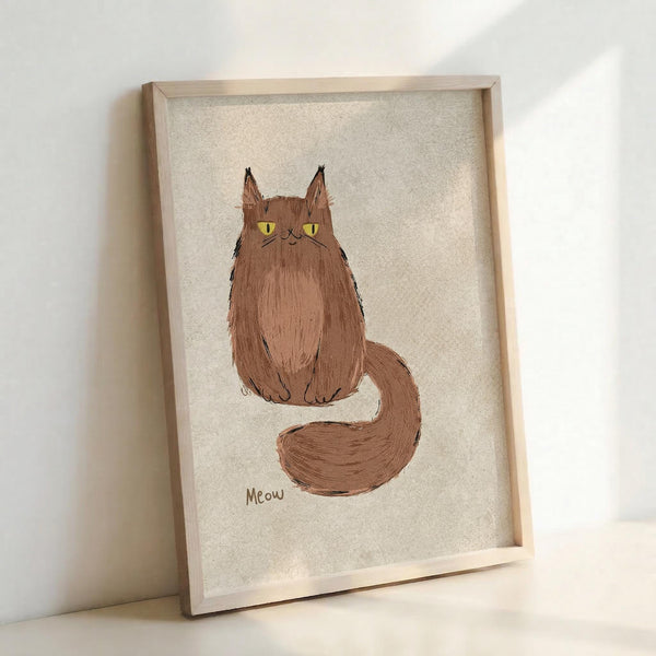 May include: Framed artwork showing a fluffy brown cat with yellow eyes sitting upright with its long tail curled around. The cat has tufted ears and the word "Meow" written below in brown text. The illustration is done in a simple, hand-drawn style on textured beige paper, displayed in a light wood frame leaning against a white wall.