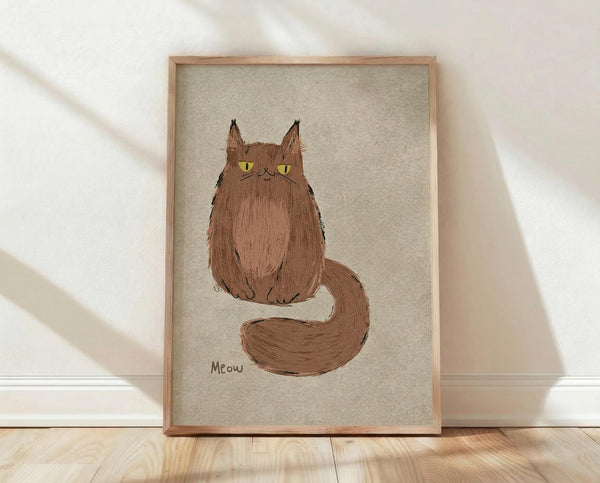 May include: Framed poster print featuring a fluffy brown cat with yellow-green eyes and long bushy tail, sitting upright with "Meow" text below. Simple sketch-style illustration on beige textured background, displayed in light wood frame leaning against white wall on natural wood floor with soft window light shadows.