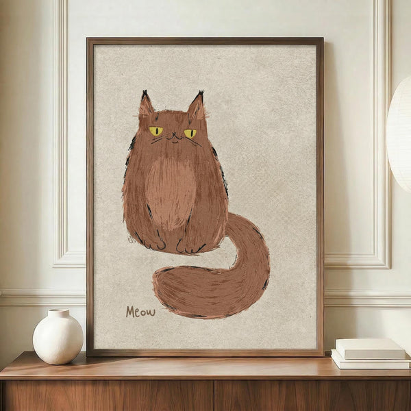 May include: Framed artwork displaying a brown cat with yellow-green eyes sitting with its fluffy tail curled around, painted in a loose, sketchy style on textured beige paper with "Meow" written below. The piece sits in a thin wooden frame on a walnut credenza next to a white ceramic vase and stacked books, against cream walls with white trim molding.