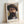 May include: Framed art print showing a bearded man in a wide-brimmed hat, painted in impressionist style with loose brushstrokes in warm browns, purples and yellows. The wooden frame sits against a white wall on a light surface, with "self portrait" and signature visible at bottom of print.