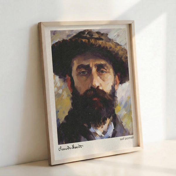 May include: Framed art print showing a bearded man in a wide-brimmed hat, painted in impressionist style with loose brushstrokes in warm browns, purples and yellows. The wooden frame sits against a white wall on a light surface, with "self portrait" and signature visible at bottom of print.