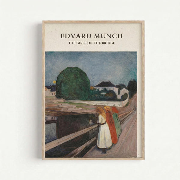 A framed art print featuring Edvard Munch's expressionist painting of three figures on a wooden bridge. The composition shows two girls in white and red dresses standing on brown wooden planks, with a large dark green tree and small houses visible in the background under a blue-gray sky. The artwork is displayed in a light wood frame against a white wall, showcasing Munch's characteristic bold colors and emotional style.