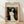May include: Framed art print of Munch's Madonna lithograph featuring a pale nude woman with long flowing black hair against orange and red background, with small skeletal figure in corner. Print has cream colored mat in light wood frame, leaning against white wall on light wooden floor with soft natural lighting casting shadows.