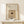 May include: Framed vintage-style espresso martini cocktail recipe poster in neutral beige tones, displayed on light wood console table against cream wall. Small white wrapped gift with twine sits beside the wooden frame. Recipe ingredients listed above illustration of dark cocktail in martini glass garnished with coffee beans.