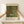 May include: Two hands holding a framed art print showing Gustav Klimt's colorful garden painting with vibrant sunflowers, wildflowers, and lush greenery in his distinctive decorative style. The print has museum-style text layout with cream matting and natural wood frame, displayed on a white wooden surface against a light wall.