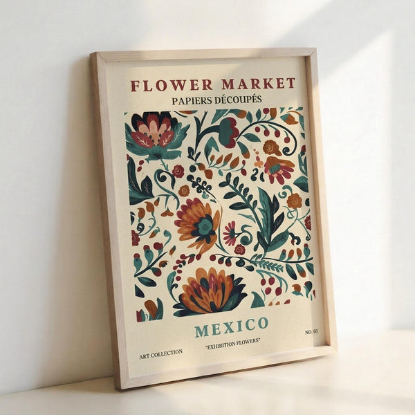 May include: Framed vintage-style botanical poster with colorful folk art flowers in orange, teal, and burgundy on cream background, displayed in light wood frame leaning against white wall on white surface. Features decorative floral motifs with "FLOWER MARKET", "MEXICO", and "EXHIBITION FLOWERS" text in classic typography style.