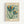 Framed vintage-style botanical poster featuring two stylized flowers with teal, navy, orange and green petals on a pale mint background. Small decorative flowers and leaves scattered throughout. Text reads "FLOWER MARKET" at top and "PARIS No.7 Papiers Découpés MUSEUM OF MODERN ART" at bottom. Light wood frame against white wall with subtle shadow.