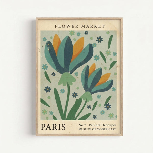 Framed vintage-style botanical poster featuring two stylized flowers with teal, navy, orange and green petals on a pale mint background. Small decorative flowers and leaves scattered throughout. Text reads "FLOWER MARKET" at top and "PARIS No.7 Papiers Découpés MUSEUM OF MODERN ART" at bottom. Light wood frame against white wall with subtle shadow.