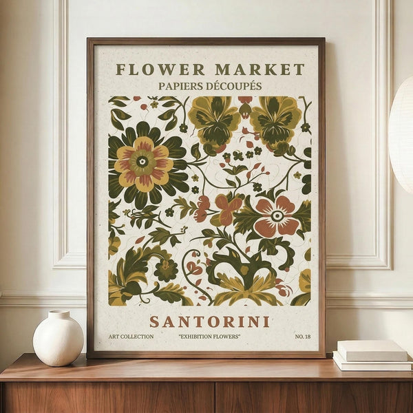 May include: Framed vintage-style botanical poster with ornate floral pattern in greens, yellows, and rust colors displayed on wooden sideboard next to white ceramic vase and stacked books. Features decorative flowers and leaves in folk art style with text headers and exhibition details on cream background in dark wood frame.
