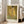 May include: A framed reproduction of Klimt's famous golden artwork showing two embracing figures in ornate robes with geometric patterns and floral motifs, displayed in a light wood frame against a beige armchair in a bright room with white walls and windows.