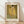May include: Framed poster print of Klimt's famous golden painting showing an embracing couple against ornate patterned robes, displayed on light wooden floor against white textured wall with natural window lighting creating soft shadows across the scene.