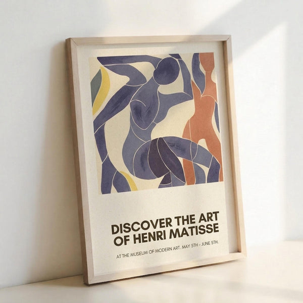 May include: Framed exhibition poster featuring abstract cut-out style figures in deep purple, coral orange, and yellow against cream background. Bold black text reads "Discover the Art of Henri Matisse" with museum and exhibition dates below. Light wood frame leans against white wall, casting soft shadows on neutral surface.