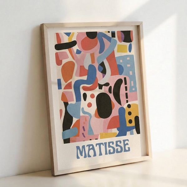May include: Framed abstract art poster with colorful geometric shapes in pink, blue, orange, yellow, and black on white background, with "MATISSE" text at bottom. Light wood frame leaning against white wall, showing modern minimalist home decor styling.