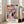 May include: Colorful abstract art poster with organic shapes in pink, blue, orange, yellow, and black, featuring "MATISSE" text at bottom, displayed in light wood frame leaning against white wall next to beige couch in bright living room with large windows and natural light
