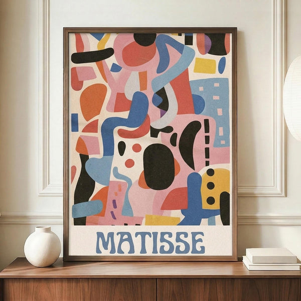 May include: Framed colorful abstract art poster with geometric shapes in pink, blue, orange, yellow and black with "MATISSE" text at bottom, displayed on wooden sideboard next to white ceramic vase and books in elegant room with cream walls and crown molding.