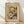 May include: Framed Henri Matisse poster print leaning against white wall on light wood floor. Abstract floral artwork features bold brushstrokes in orange, pink, blue, green and white with flowing organic shapes. Cream matting surrounds colorful botanical design. Quote "creativity takes courage" appears below image. Natural light casts diagonal shadows across scene.
