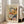 May include: Framed art print featuring colorful floral painting with orange, pink, white and blue blooms against cream background. Henri Matisse text at top with "creativity takes courage" quote below. Light wood frame leaning against white wall next to beige upholstered chair in bright, minimalist living room with hardwood floors and large windows.