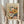May include: Person in cream sweater holding framed Henri Matisse-inspired floral art print featuring abstract flowers in soft oranges, pinks, greens, and blues with "creativity takes courage" quote below. Dried pampas grass visible on left side against neutral background with natural window lighting.