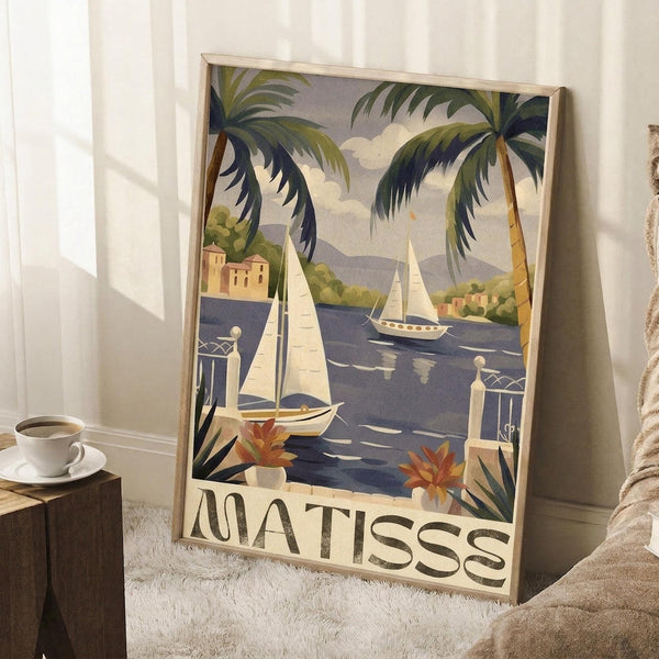May include: Framed vintage-style travel poster featuring tropical coastal scene with palm trees, sailboats on blue water, Mediterranean buildings, and "MATISSE" text at bottom. Poster leans against white wall next to coffee cup on wooden surface and beige textured throw blanket in corner of bright room.