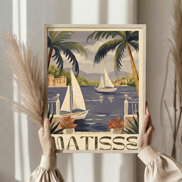 May include: Person holding framed vintage travel poster featuring tropical Mediterranean scene with sailboats on blue water, palm trees, coastal buildings, and decorative balustrade with potted plants. Warm color palette with yellows, blues, and greens in classic mid-century illustration style. Light wood frame against neutral curtained background with dried pampas grass visible.