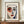 May include: Framed art poster featuring abstract portrait with stylized face, red circular area around left eye, blue shadowing on right side, dark eyebrows, red lips on cream background. Henri Matisse text at top with French subtitle and inspirational quote below. Brown wooden frame displayed on light wood sideboard with white ceramic vase, neutral wall background.