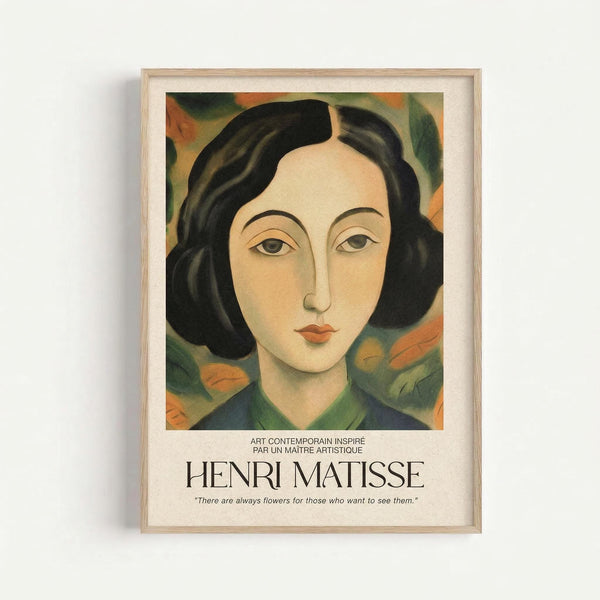 A framed art print featuring a stylized portrait of a woman with dark wavy hair and pale skin against a colorful abstract background of green, orange, and yellow brushstrokes. The artwork has a modernist style with simplified facial features and bold colors. Below the image is text reading "ART CONTEMPORAIN INSPIRÉ PAR UN MAITRE ARTISTIQUE" followed by "HENRI MATISSE" and a quote about flowers. The print is displayed in a light wood frame against a white wall.
