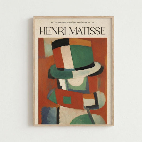 May include: Framed art poster featuring a colorful abstract portrait in Matisse's distinctive style, showing a figure wearing a striped hat rendered in bold blocks of green, orange, red, white and black. The minimalist composition uses geometric shapes and vibrant colors against a warm orange background. Displayed in a light wood frame on a white wall.