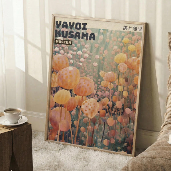 May include: Framed poster featuring Yayoi Kusama's polka dot artwork with yellow, orange, and pink circular forms on green background, displayed in light wooden frame leaning against white wall next to beige textured blanket and wooden side table with white coffee cup and saucer on white fluffy rug