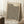 May include: Framed art print leaning against white wall featuring black polka dot pattern on cream background with "YAYOI KUSAMA" text and "TOKYO 1992" in upper corner, Japanese text at bottom. Light wood frame, displayed in cozy room setting with coffee cup on wooden block side table and soft textured throw blanket visible.