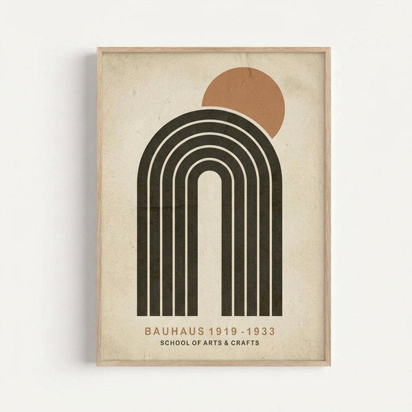 Framed minimalist poster featuring a dark olive green rainbow arch with white stripes and a rust-colored circle positioned at the upper right, resembling a sun. The design sits on a cream textured background with "BAUHAUS 1919-1933 SCHOOL OF ARTS & CRAFTS" text below in brown lettering. The artwork is displayed in a light wood frame against a white wall, showing subtle shadows around the frame edges.