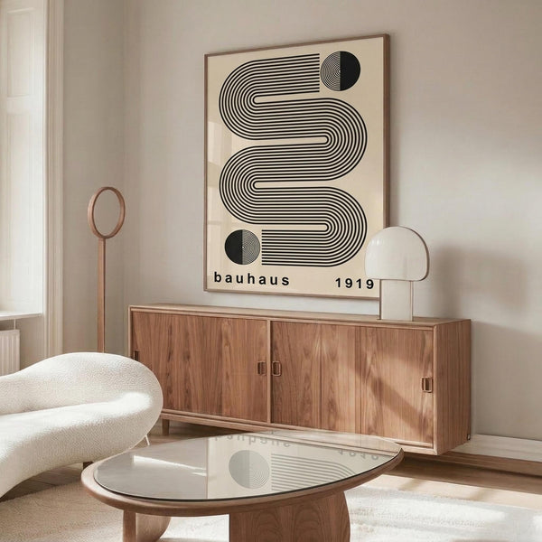 May include: Framed Bauhaus-inspired poster with black geometric wavy lines and circles on cream background, displayed above wooden sideboard in modern living room with white sculptural chair, glass coffee table, and minimalist decor in neutral tones.