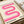 May include: Pink wavy ribbon design poster with cream background displayed on wooden surface next to rolled white fabric. The minimalist artwork features flowing curved lines in gradient pink tones from light to deep magenta, with "bauhaus 1919" text at bottom in black letters. The print appears in a thin wooden frame against neutral textured materials.
