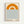 A framed minimalist poster featuring a large orange semi-circle resembling a sun with a smaller concentric arc inside, positioned above horizontal blue wavy lines representing water. The design uses a cream background with "bauhaus" and "1919" text at the bottom. The artwork is displayed in a light wood frame against a white wall.