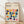 May include: Framed Bauhaus poster with colorful geometric half-circle and curved shapes in yellow, pink, orange, navy, teal, and purple on cream background. Modern minimalist design leaning against white wall on light wood floor with soft natural lighting and shadows.