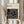 May include: Person in cream sweater holding framed Bauhaus poster against white curtained window, with dried pampas grass beside them. Black geometric maze-like design on cream background with "BAUHAUS" text and "Modernism, minimalism & abstract arts 1919-1933" subtitle. Light wood frame complements neutral aesthetic setting.