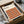 May include: Framed Bauhaus poster with geometric pattern of overlapping circles in warm autumn colors - orange, burgundy, brown, and tan - displayed in black frame, nestled in cardboard shipping box with protective tissue paper wrapping