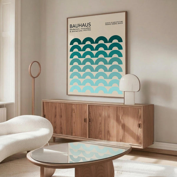 May include: Framed Bauhaus poster with teal geometric wave pattern displayed above wooden sideboard in modern living room. White sculptural chair and glass coffee table visible. Poster features graduated blue-green semicircles creating rhythmic wave design against cream background. Natural wood furniture and minimalist white table lamp complete the scene.