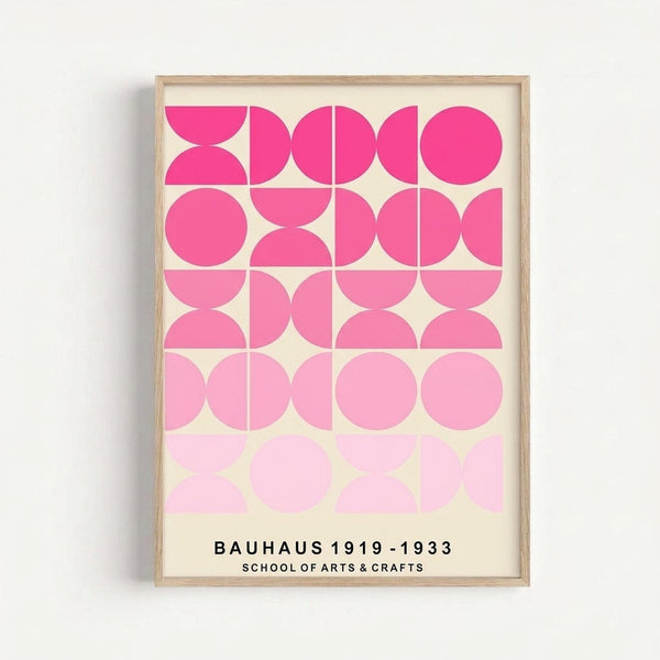 Framed geometric poster with pink gradient circles and semicircles arranged in a 4x5 grid pattern, transitioning from bright hot pink at top to pale pink at bottom. Text at bottom reads "BAUHAUS 1919-1933 SCHOOL OF ARTS & CRAFTS" in black letters. Light wood frame against white background with subtle shadow.