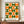 May include: Framed geometric poster with green and orange circles and semicircles arranged in a grid pattern on cream background, displayed on wooden sideboard next to white ceramic vase and stacked books in modern interior with white paneled walls.