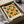 May include: Framed geometric art print with repeating pattern of orange and green half-circles arranged in a grid on cream background. Black frame nestled in cardboard shipping box with protective tissue paper wrapping. Mid-century modern Bauhaus-inspired design with clean lines and bold color contrast.