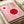 May include: Pink and red geometric Bauhaus-style poster print displayed on white surface next to beige ribbon roll. Abstract design features two circular forms with white outlines on pink background, black text reading "bauhaus" and smaller text below. Modern minimalist art print shown in styled flat lay photography setup.